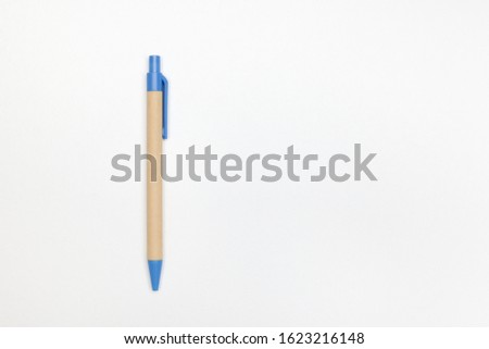 Pen made from environmental material, recycled paper on a white background with copy space. Blank for designers. Top view.
