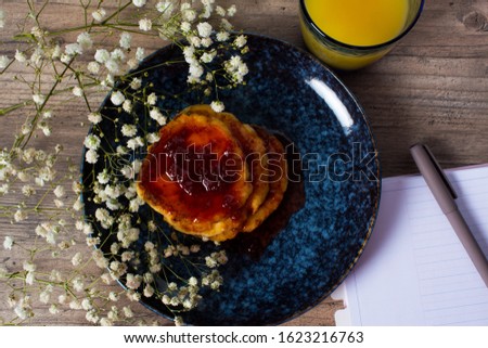 Beautiful Breakfast. Pancakes with jam and orange juice. Flowers and stylish dishes. A diary with blank pages. A healthy life style. Flat lay. Luxury decor.