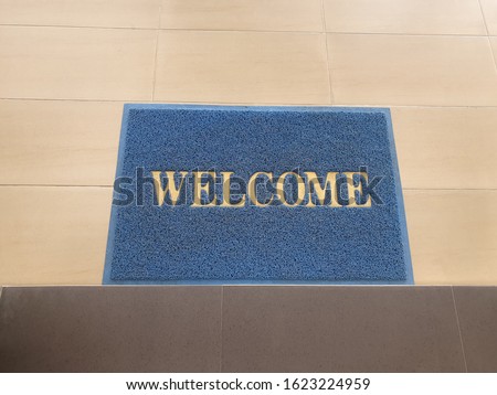 welcome text on old blue doormat  on floor