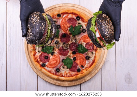 
pizza with sausage mushrooms tomato and olives and two burgers on a white background1