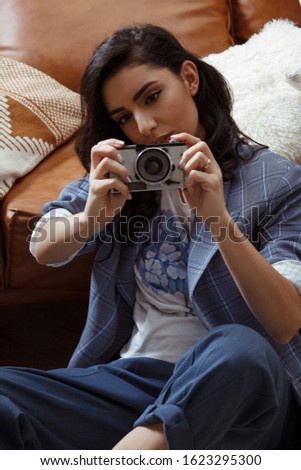 Portrait of caucasian young woman holding old photo camera