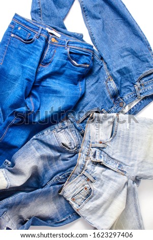 jeans in various shades of blue are taken in close-up on a white background. flat lay, vertical frame.