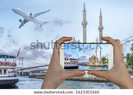 Tourist taking a picture in front of Ortakoy mosque and Bosphorus bridge, Istanbul, Turkey. Travel concept