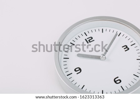 white with light metal minimalistic wall clock close-up on a light background