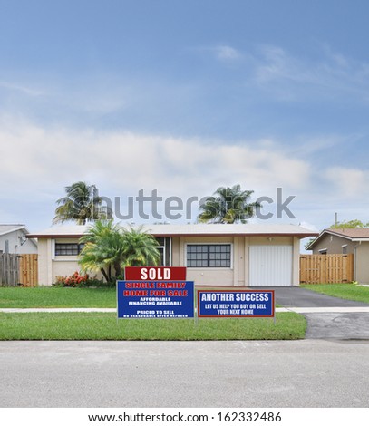 Sold For Sale Real Estate Sign Another Success Let Us Help You Buy Sell Your Next Home Suburban Ranch style House Residential Neighborhood Blue Sky Clouds Palm Trees