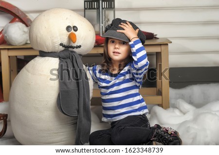 Little girl with a toy snowman at home