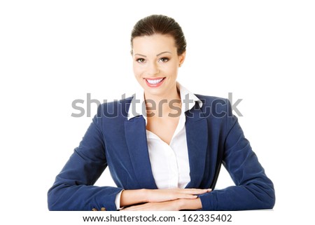 Attractive business woman sitting and smiling.  Isolated on white. 