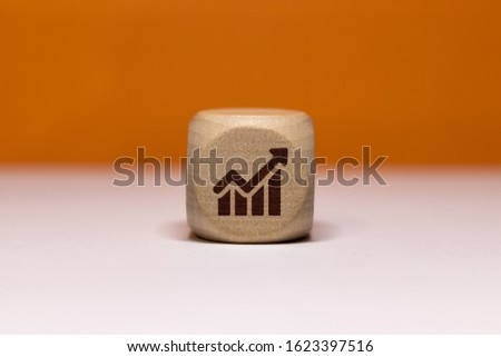 Economic growth icon on wooden cube on orange background