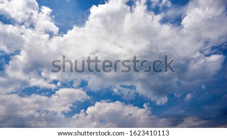 Fragment of a blue sky with white clouds. Summer beautiful sunny day. Moving colorful background for screensaver.