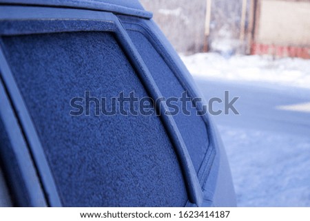 Texture of snow-white snowflakes on the surface of the car. Beautiful snow frosty pattern on the window of the car. Winter Wallpaper with frosty snowflakes on the glass.