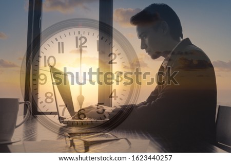  Businessman working early morning at office typing on computer. Time management, hard work, successful habits concept.  Royalty-Free Stock Photo #1623440257