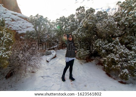 Beautil Latina woman doing a selfie wearing a jacket in a cold weather over the snow.