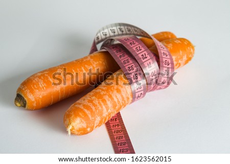 Organically grown carrots with tape measure. fresh fruit and vegetables are always healthy. symbol photo for healthy diet.