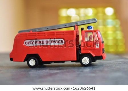 Red color fire truck toy on the abstract background 