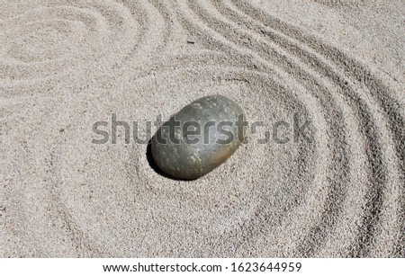 Garden of stones. Harmony and contemplation of the rock garden. Sand with centric circles and stones on the sand.