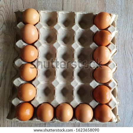 Close-up view of raw brown chicken eggs in egg box on wooden background with "A to Z" collection  as "U" alphabet for valentine day