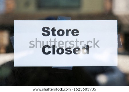store closed sign. a store closed sign taped to the inside door of an empty building. 