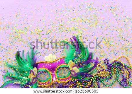 Holidays image of mardi gras masquarade venetian mask over purple background. view from above