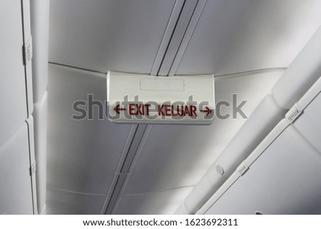 The exit sign in English and Indonesian on board the aircraft.