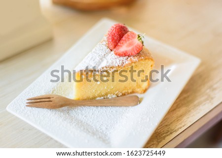 soft cake with stawberry and ice coffe on table