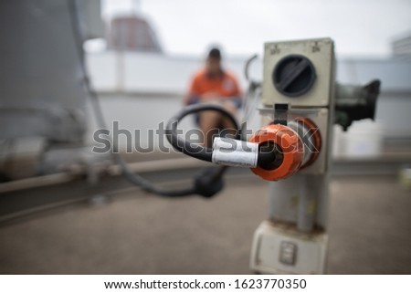 Defocused of building maintenance unit electrician inspecting holding paperwork clear powerpoint tag its attached onto BMU is good condition prior to work at high rise building Sydney CBD Australia 