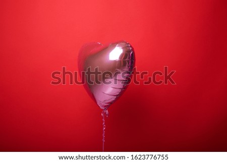 Balloon heart on a red isolated background.