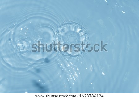 top view Closeup blue water rings, Close-up water droplets affect the surface, forming rings on the surface. reflections in water. Radial waves from a rain on water. Circles and rings on the puddle.