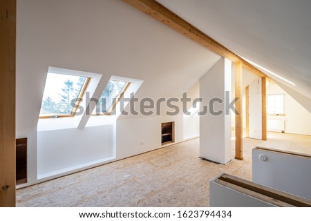 Converting an old attic into a light spacious living room Royalty-Free Stock Photo #1623794434