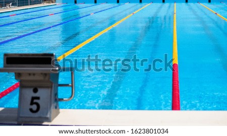 Empty swimming pool with competition lanes. Texture of classic blue water. 