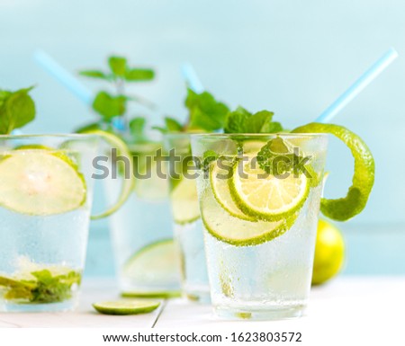 Lime soda a glass on a white wooden floor in a light blue background, summer drinks nonalcoholic
