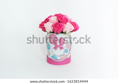 Flowers in bloom: A bouquet of pink and white roses in a round box on a white background.