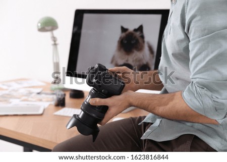 Professional photographer with camera in office, closeup