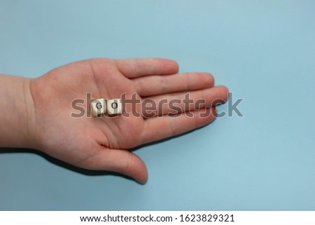 Inspirational word go on letter cubes in child's hand. Motivation concept.