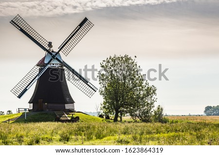 East Frisian landscape with windmill near the town of Leer, East Frisia, Lower Saxony, Germany  Royalty-Free Stock Photo #1623864319