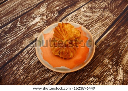 Sweet pie on a round plate. Photo. Wooden background.