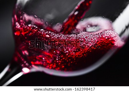  Red wine in wineglass on  black background Royalty-Free Stock Photo #162398417