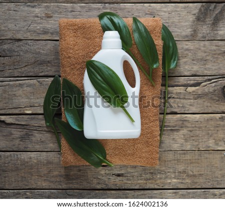 Eco blank design packaging of natural bottles among green grass. Bio organic detergent product. Green leaves of plants.