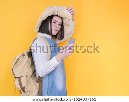 Portrait of asian women taking a selfie photo with smart phone in studio on yellow background. Modern youth lifestyle and travel concept.