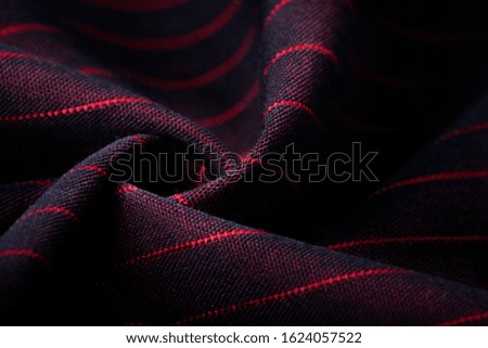 Texture, background, template. Silk other Cotton fabric black and red, silk other Cotton drapery. In closeup, threads of fabric and a pattern of textures are visible.