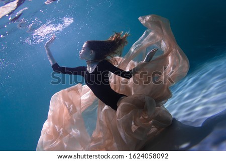 Young Slender Girl Underwater with a Cloth. Water Magic. Underwater Photography. Art Royalty-Free Stock Photo #1624058092