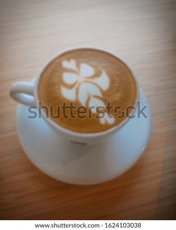 Blurry image of coffee latte art on cafe tables from top view. good for your project and wallpaper.