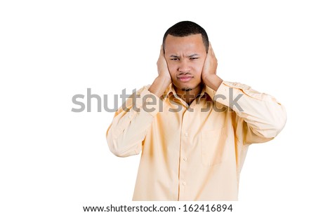 Closeup portrait of attractive young man covering his ears, closing his eyes, isolated on white background with copy space. Hear no evil concept. Human emotions, expressions and communication signs