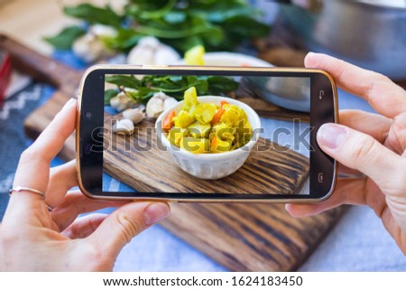 Take picture with smartphone. Phone food photography. Vegetables stew. Vegan food and healthy diet.