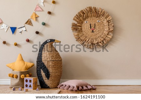 Stylish scandinavian interior of child room with natural toys, hanging decoration, pillows, plush animals, teddy bears and accessories. Beige walls. Interior design of kid room. Template. Copy space.