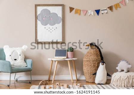 Stylish and beige scandinavian interior of kid room with mock up poster frame, design furnitures, natural toys, hanging colorful flags, plush animal and child accessories and teddy bears. Home decor.