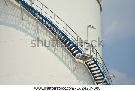 Refinery oil tank with stairway. Storage tank with ladder.