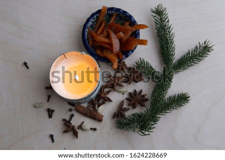 Still life picture with anise starts, pine branch, candle, and cinnamon