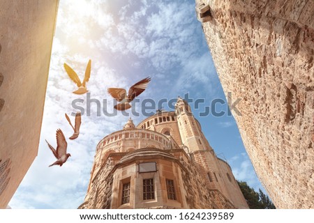 View of the top of the Franciscan Monastery in Jerusalem or Dormishen Abbey with flying doves, Israel Royalty-Free Stock Photo #1624239589