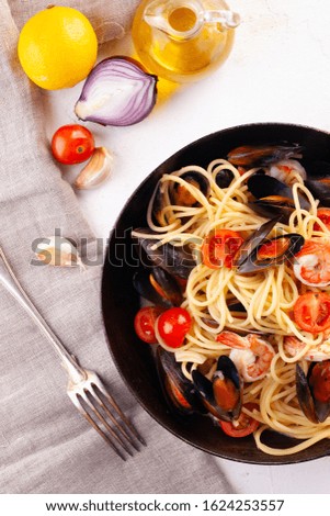 The pasta with seafood. Spaghetti with mussels and tiger prawns, traditional pasta with prawns close-up on a frying pan