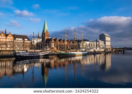 Ships are on the Weser promenade in Bremen and are reflected in the water
